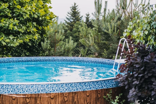 Une piscine extérieure, nichée au milieu des arbres et des plantes, offre un cadre paisible et rafraîchissant en pleine nature