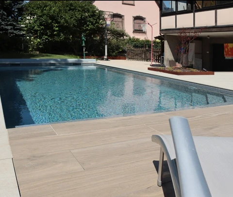 Espace extérieur résidentiel avec piscine rectangulaire à débordement, eau turquoise cristalline