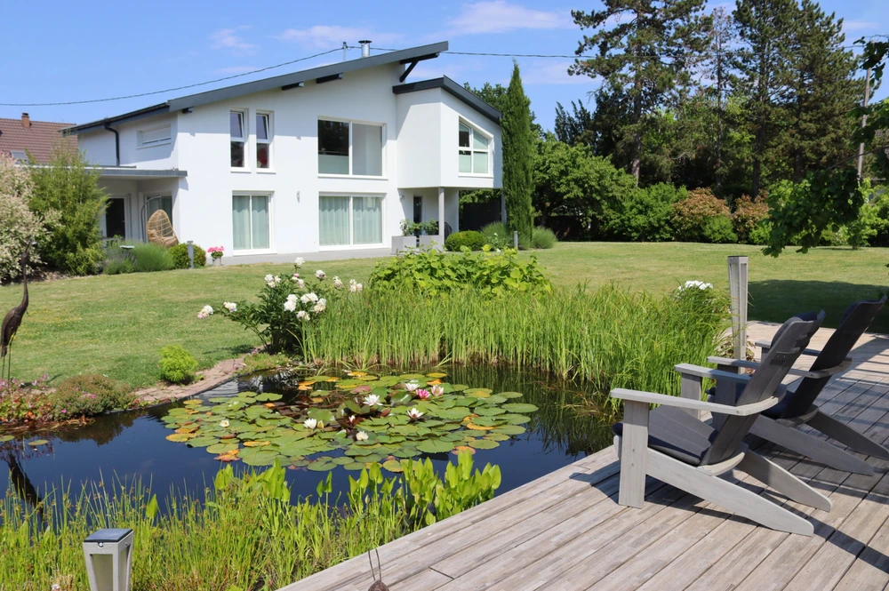 Jardin paysager avec bassin d'agrément et terrasse en bois