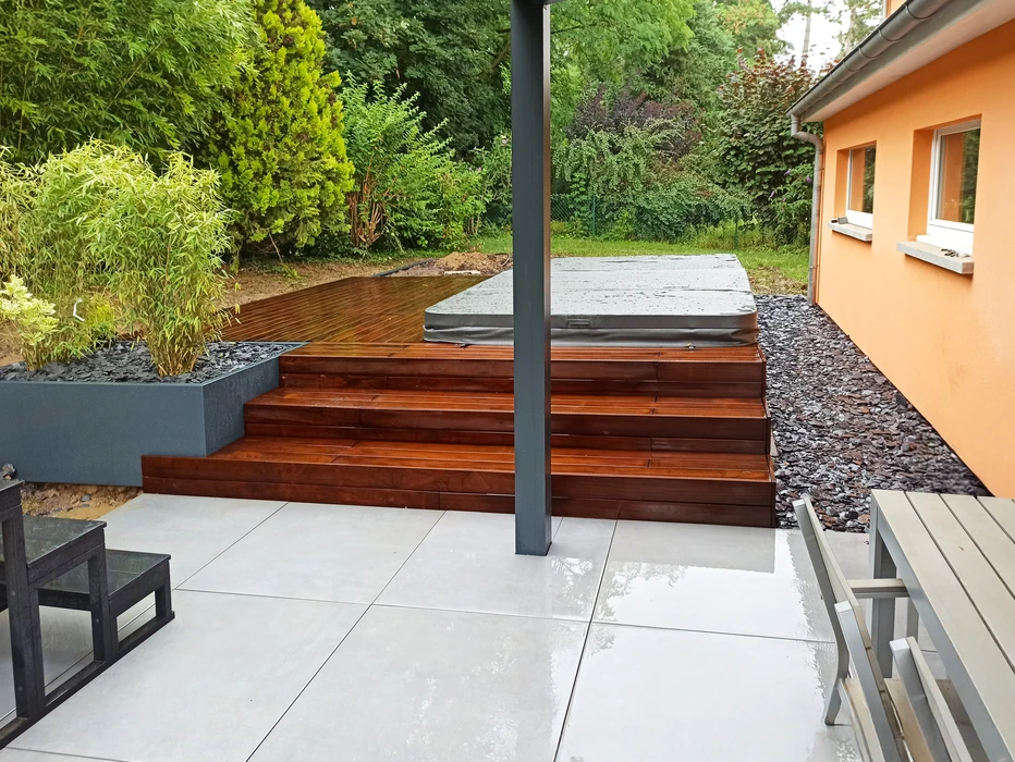 Espace extérieur résidentiel avec piscine rectangulaire à débordement, terrasse en dalles de béton beige