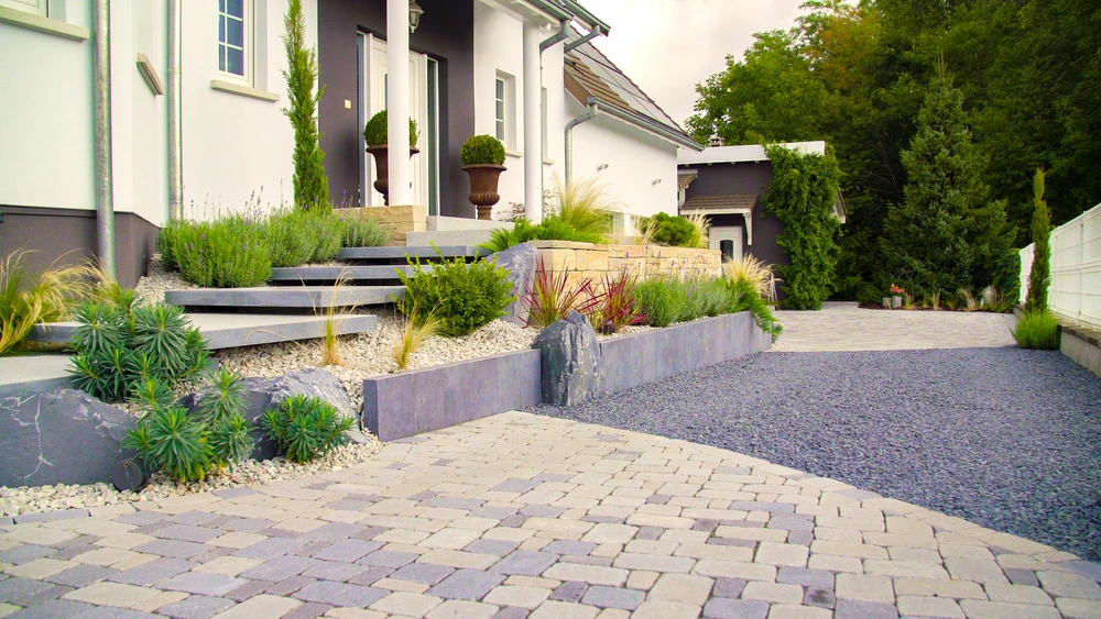 Terrasse extérieure avec piscine rectangulaire aux eaux turquoise, entourée de dalles en béton gris clair disposées en motif régulier