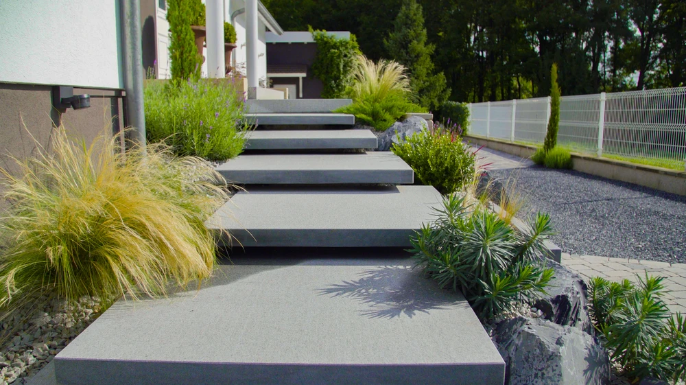 Espace extérieur avec piscine aux eaux turquoise, terrasse en dalles de pierre et platelage bois