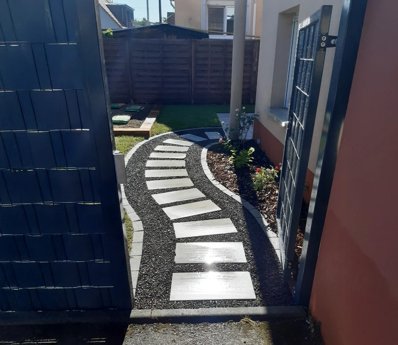 Scène extérieure d'aménagement paysager en terrasses avec escalier en pierre naturelle, murets de soutènement, plantation de cyprès, lavandes et arbustes méditerranéens