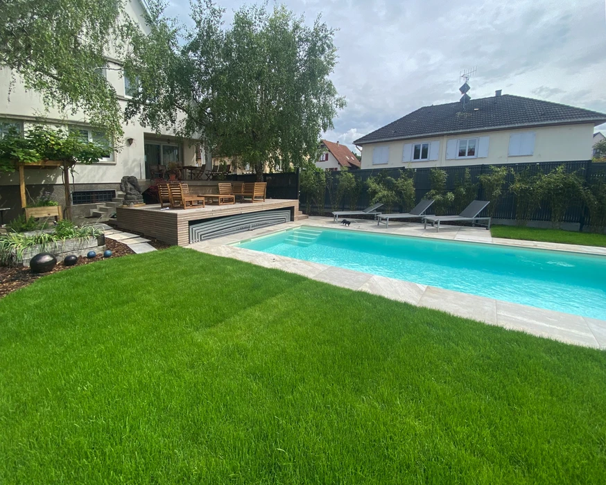 Espace extérieur contemporain avec piscine rectangulaire à débordement, terrasse en dalles de pierre naturelle claire