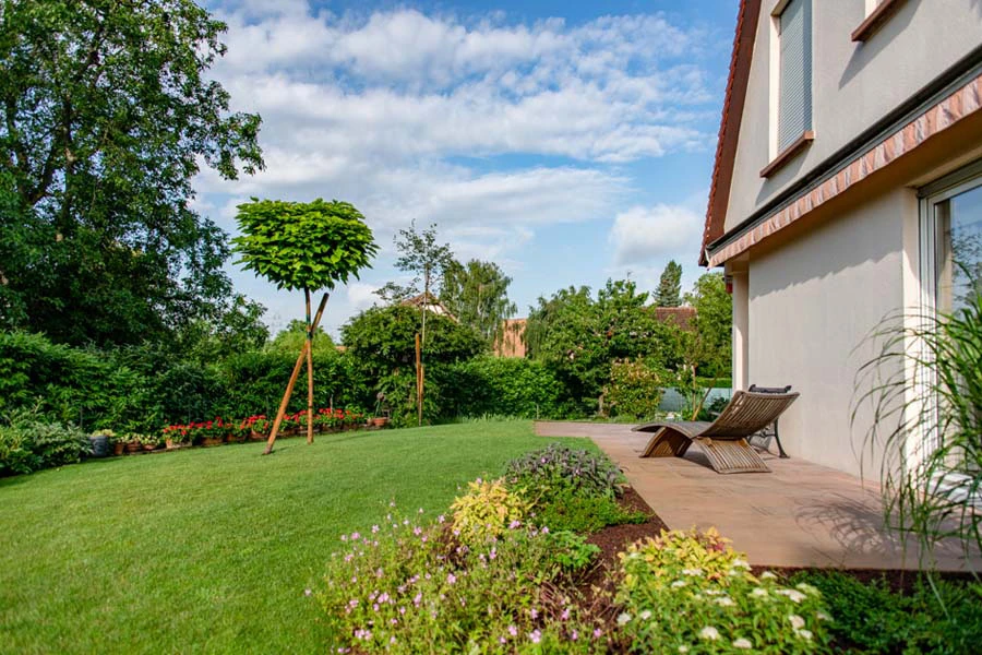 Jardin contemporain avec terrasse aménagée comprenant salon d'extérieur gris, pergola moderne et mobilier design