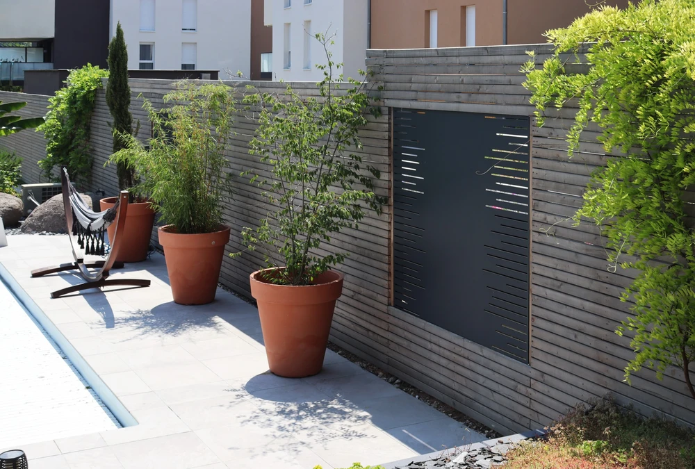 Scène extérieure résidentielle avec portail et clôture métalliques contemporains devant maison individuelle